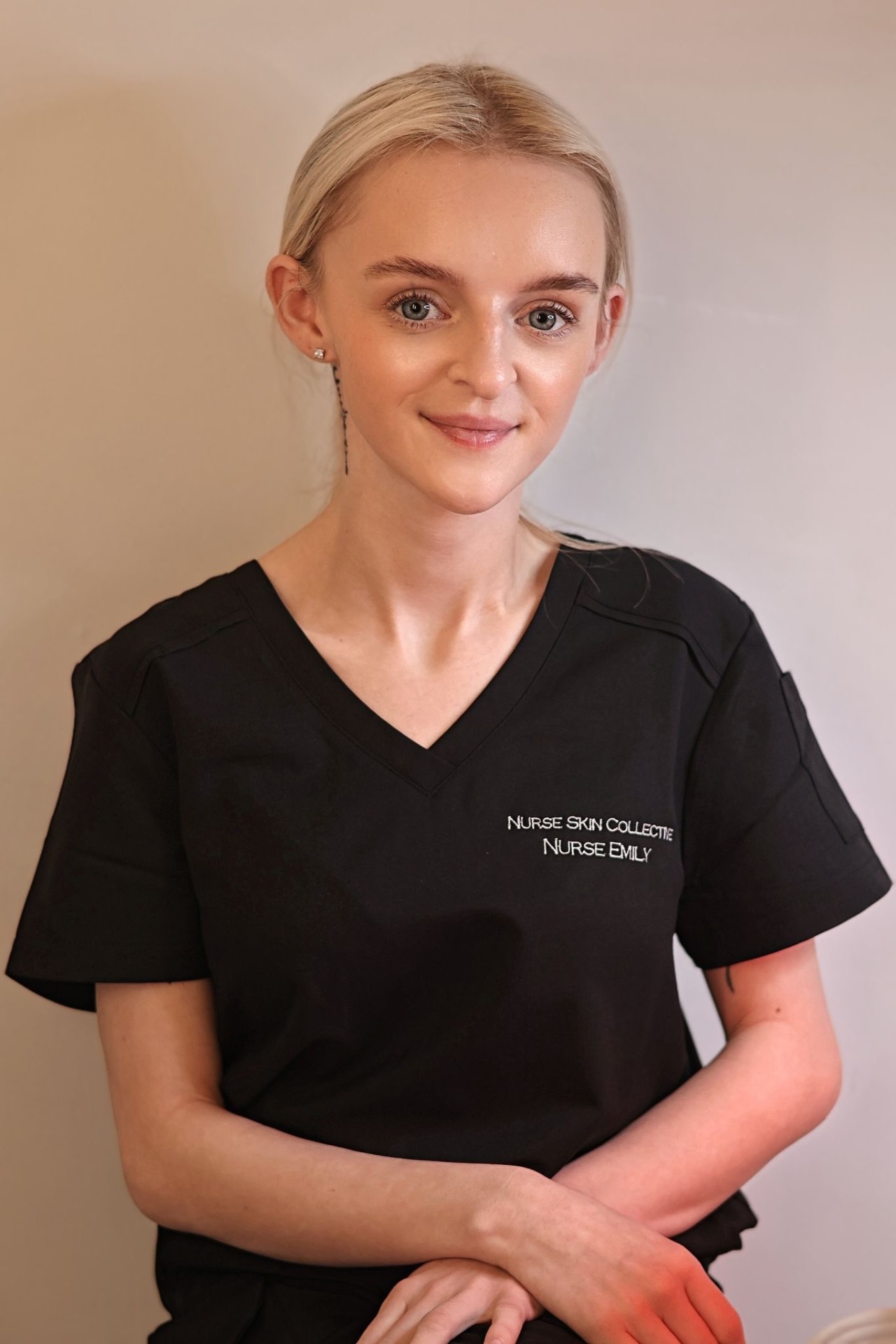 Nurse Emily of Nurse Skin Collective holding a branded mirror